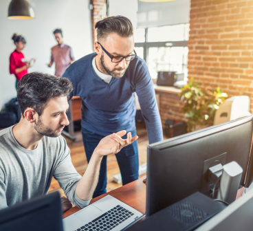Senior consultants reviewing strategy at a workstation